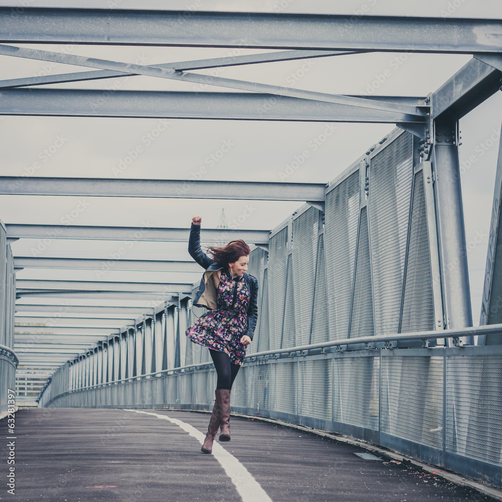 Pretty girl walking happy on a bridge