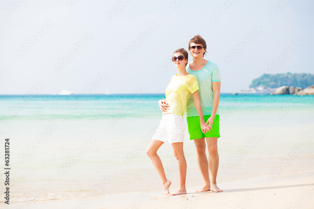 front view of couple hugging and holding hands on tropical beach front view of couple hugging and holding hands on tropical beach