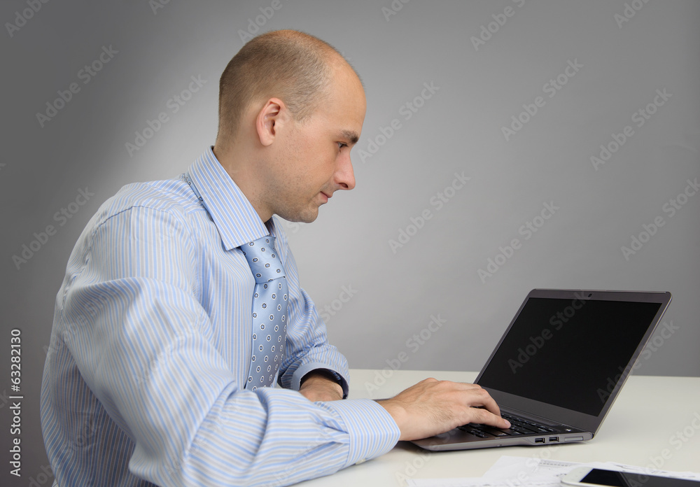 Handsome businessman working with laptop in office Handsome businessman working with laptop in office