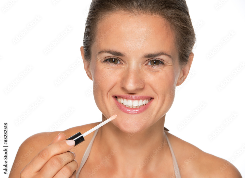 Happy young woman applying lip gloss Happy young woman applying lip gloss