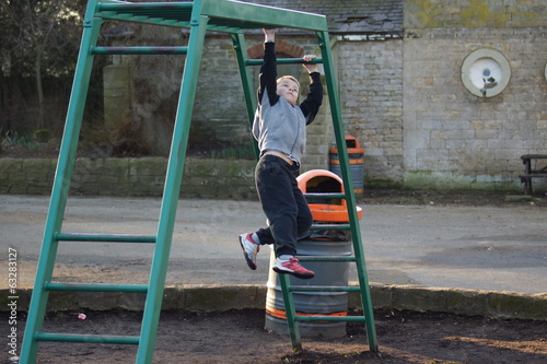 Young boy climbing on monkey bars