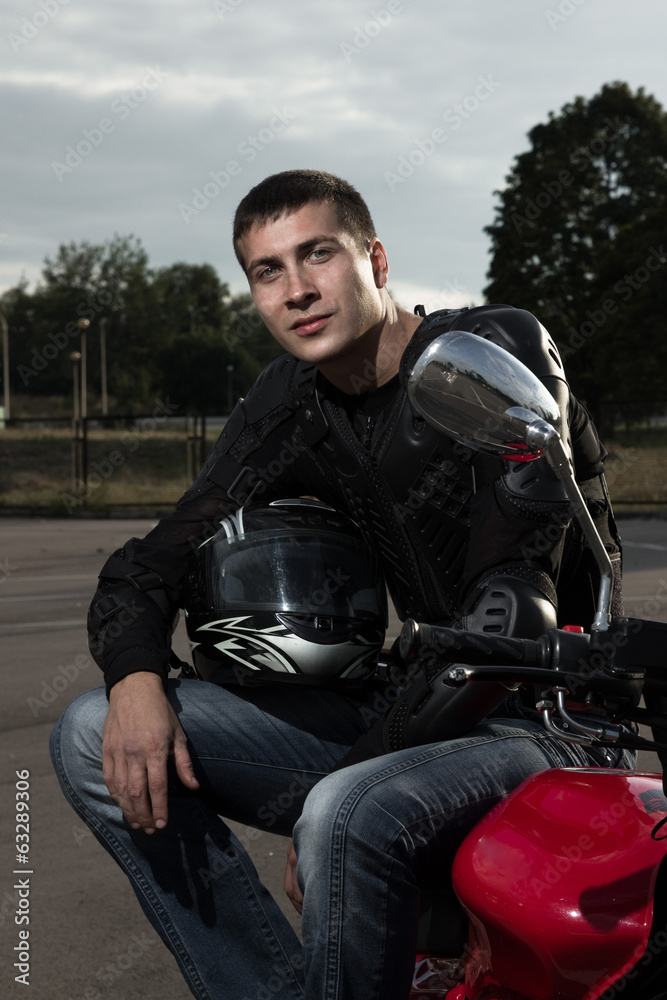 Closeup portrait of young biker sitting on sportmotorcycle