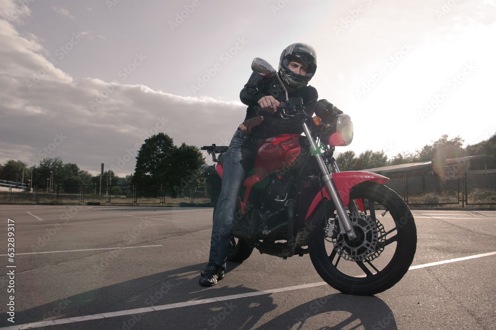 Fototapeta rowerzysta w kasku pozowanie na motocyklu
