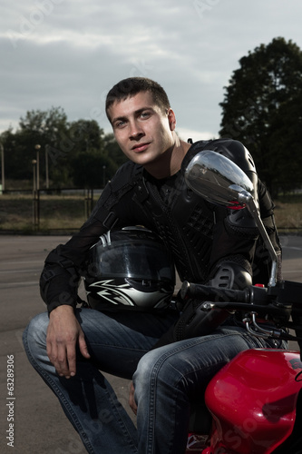 Closeup portrait of young biker sitting on sportmotorcycle © rasstock