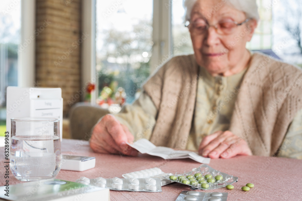 Elderly woman with pills - obrazy, fototapety, plakaty 