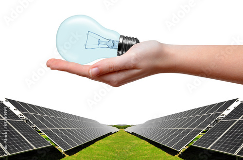 Solar energy panels and bulb in hand