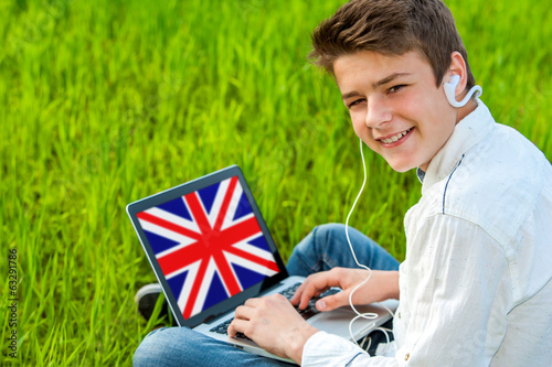 Teen learning english on laptop outdoors. photo