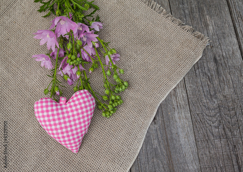 Rustic still life with a bouquet of pink mallow and heart photo