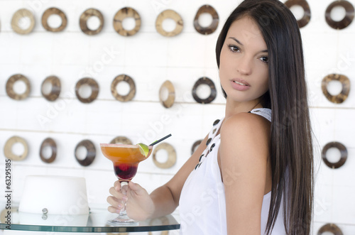Woman drinking a cocktail on the beach at a party