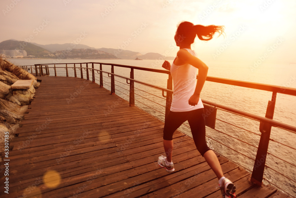 Fototapeta premium fitness young asian woman running sunrise seaside