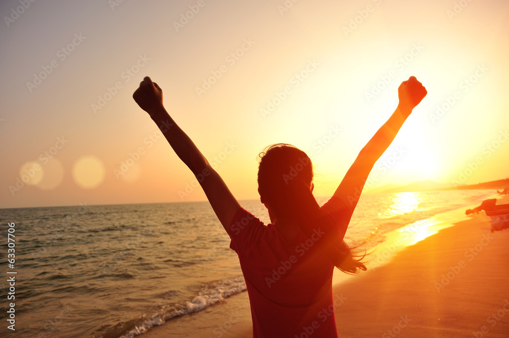 cheering woman hiker open arms at sunrise seaside 