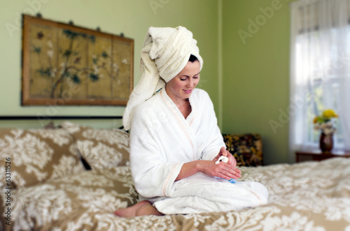 Young woman applies moisturiser to her skin