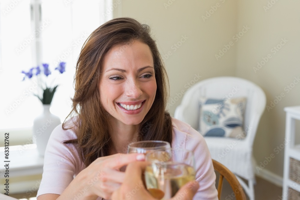 Smiling woman toasting wine glass at home Smiling woman toasting wine glass at home