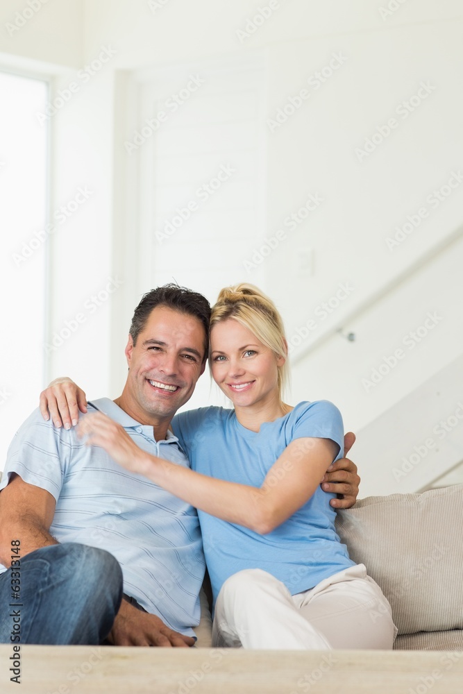 Portrait of a loving couple sitting on sofa in living room Portrait of a loving couple sitting on sofa in living room
