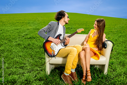 Man playing lovely song to the girl that like it on the couch on