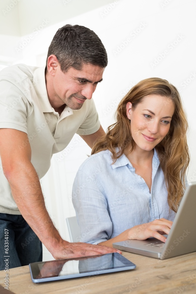 Couple using laptop at table Couple using laptop at table