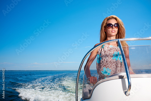 Summer vacation - young girl driving a motor boat © ZoomTeam