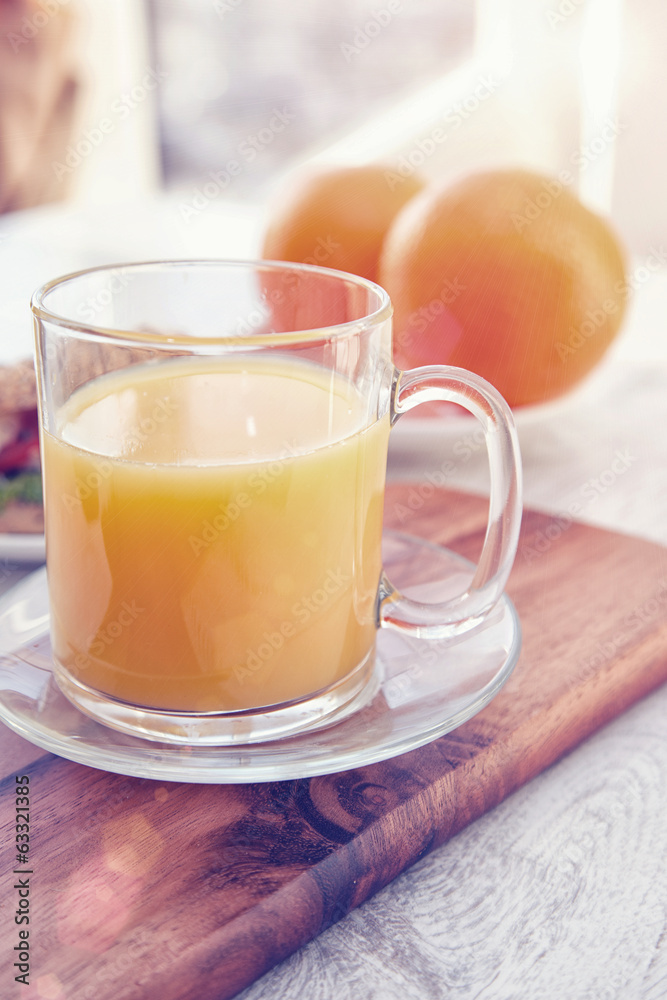 Cutting board with oranges and a cup of juice Cutting board with oranges and a cup of juice