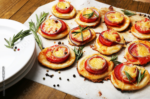 Small pizzas on baking paper close up