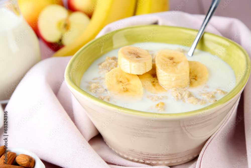 Tasty oatmeal with bananas and milk on table close up Tasty oatmeal with bananas and milk on table close up