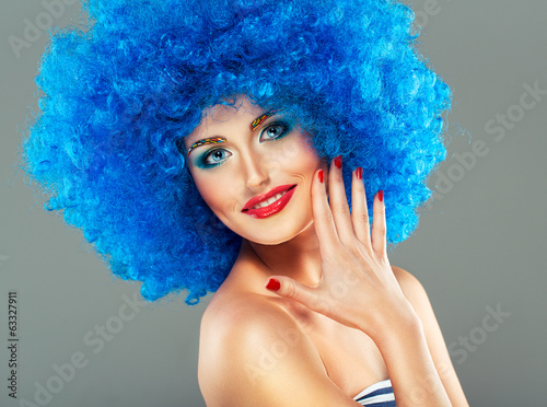 Portrait of a young beautiful girl with bright makeup in blue wi