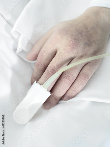 Hand an elderly patient man lying in bed
