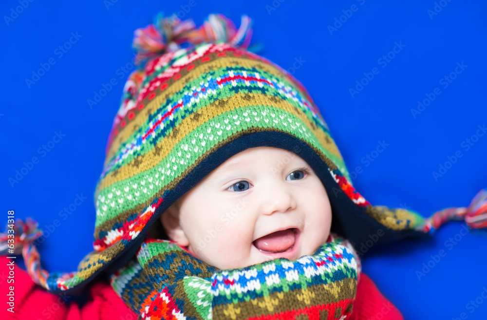 Laughing happy baby wearing a funny knitted hat and scarf Laughing happy baby wearing a funny knitted hat and scarf