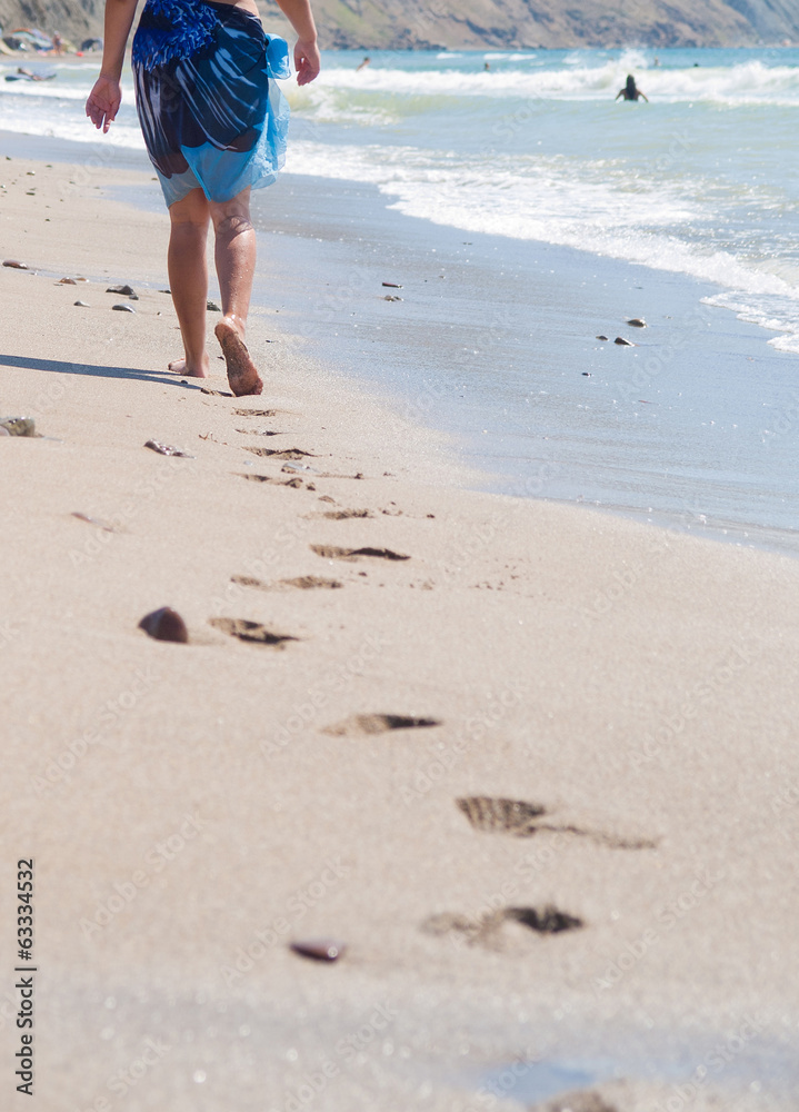 woman walking on the sand beach woman walking on the sand beach