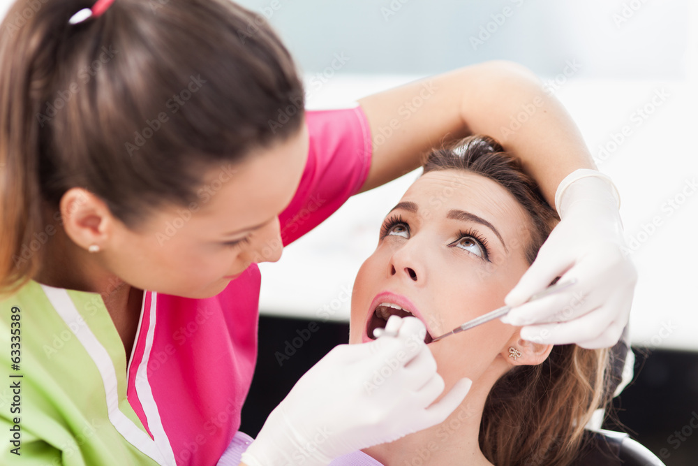 Woman dentist checking her patient's teeth