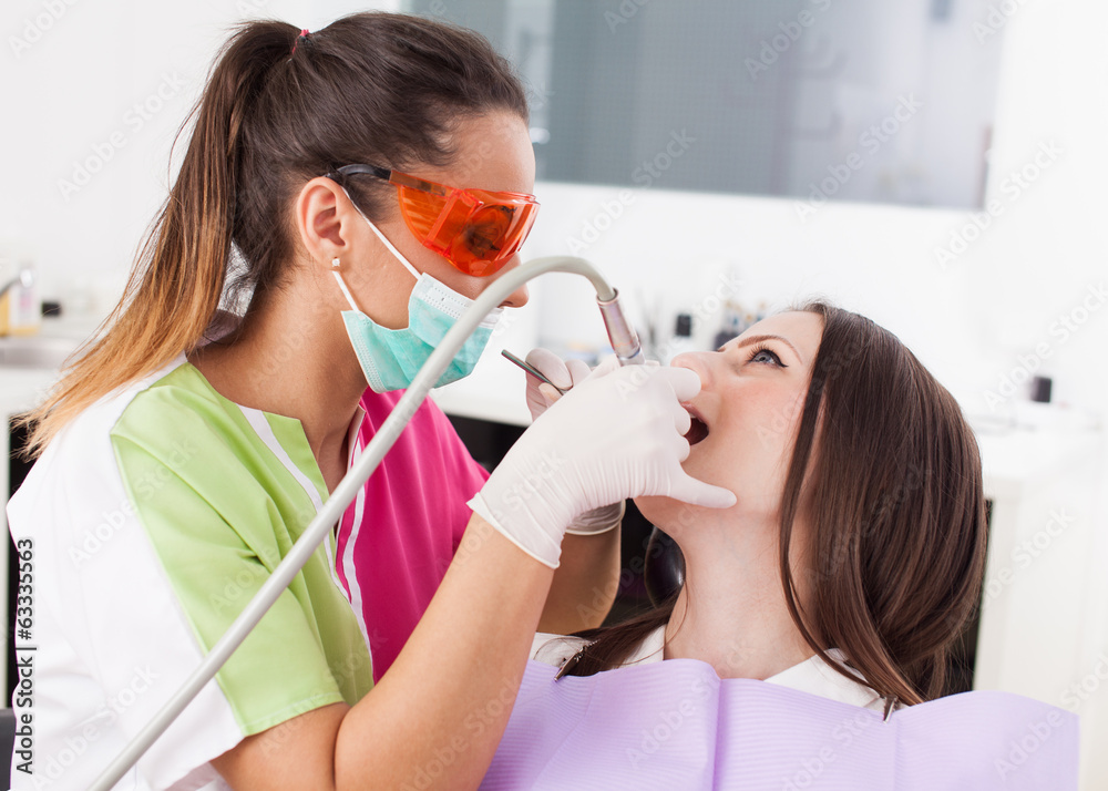 Woman dentist working with the driller Woman dentist working with the driller
