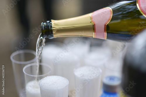 Schilderij op canvas Someone poured a bottle champagne in glasses