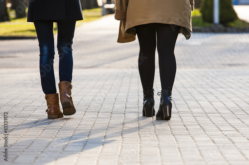 Young women walking on the sidewalk. © gashgeron