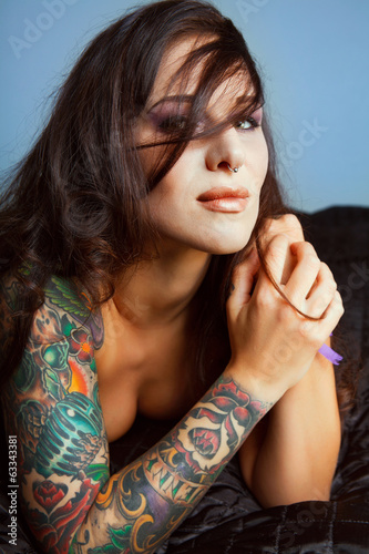 Beautiful girl with stylish make-up and tattooed arms ..