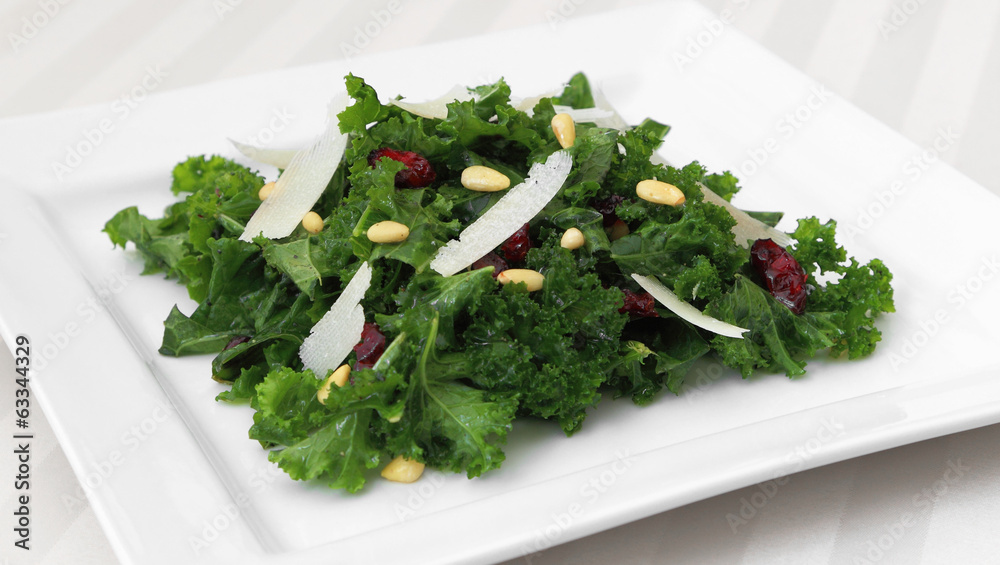 Kale salad served on a square plate. Kale salad served on a square plate.