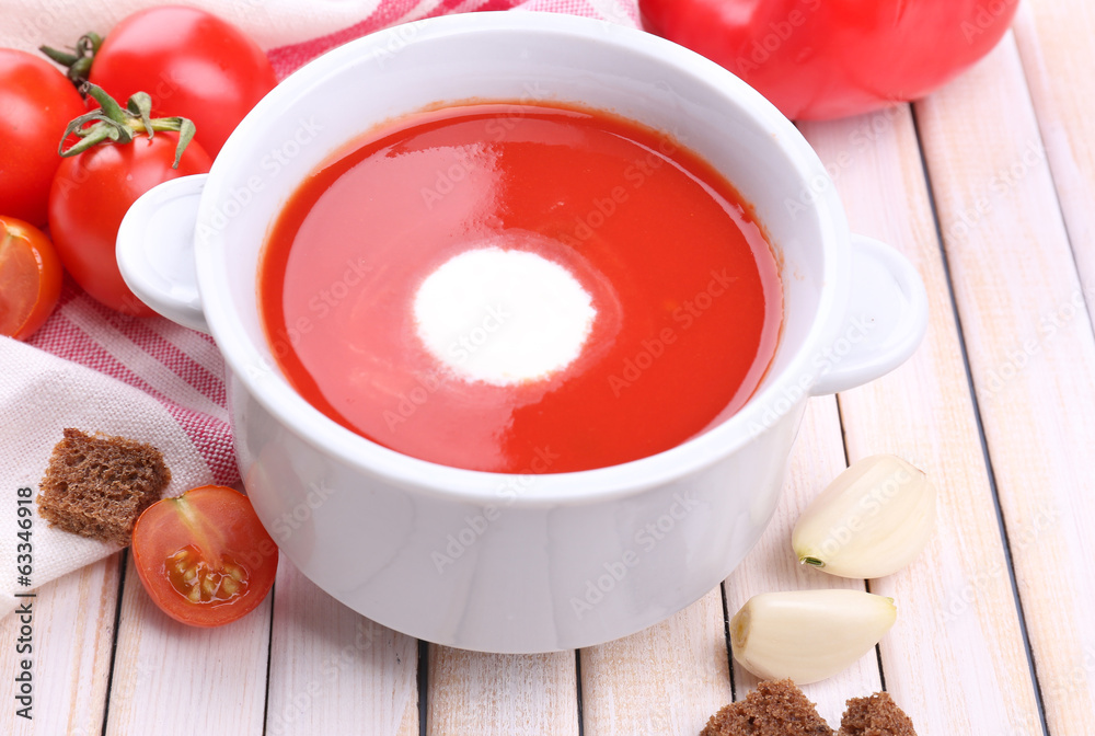 Tasty tomato soup and vegetables on wooden table Tasty tomato soup and vegetables on wooden table