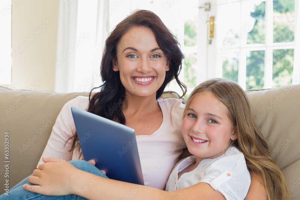 Mother and daughter with digital tablet on sofa Mother and daughter with digital tablet on sofa