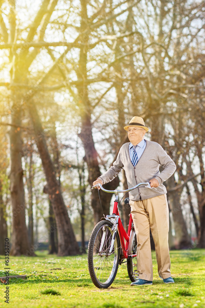 Senior man walking with his bike outdoors Senior man walking with his bike outdoors