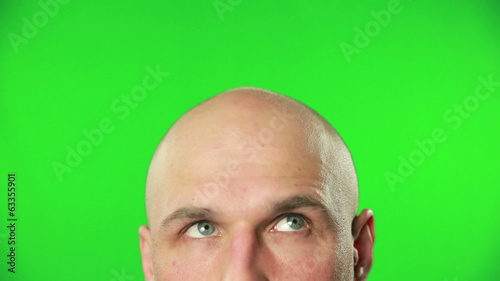 Close up of male head and eyes against a green screen
