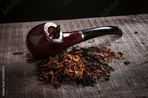 pipe and tobacco on wooden surface