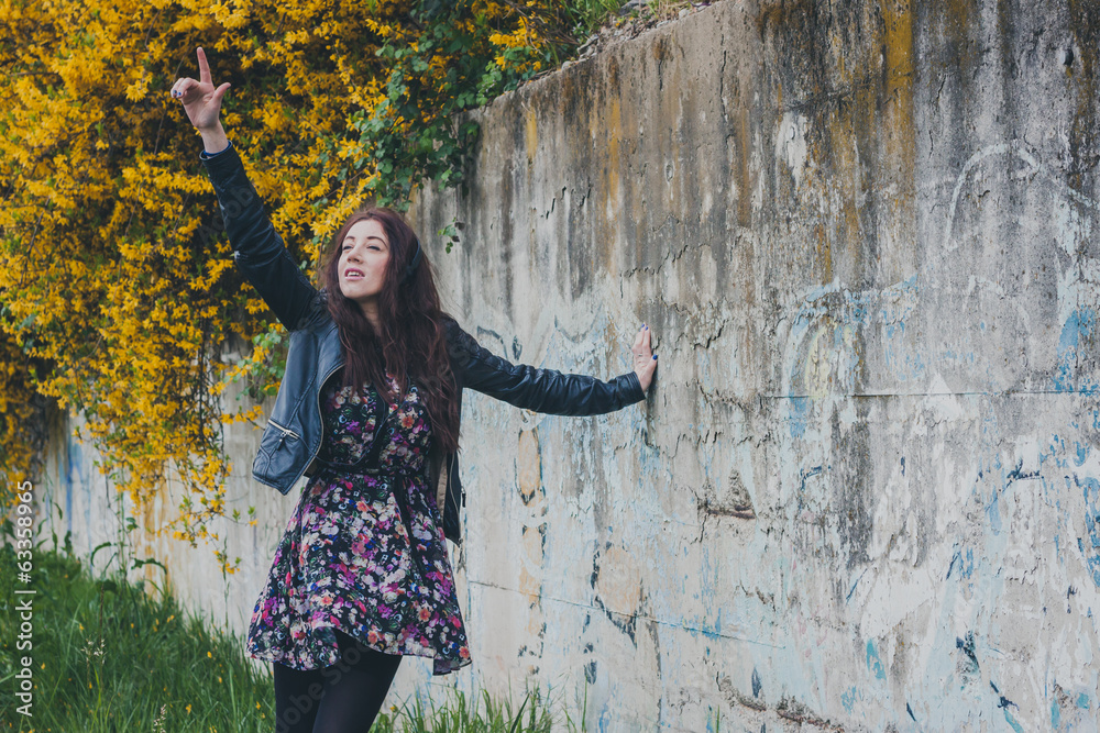 Pretty girl with long hair leaning against a concrete wall Pretty girl with long hair leaning against a concrete wall