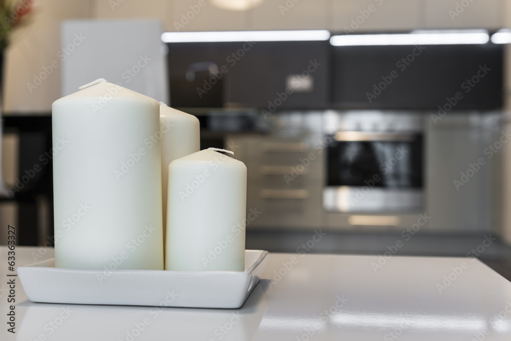 Three candles with defocus kitchen in background Three candles with defocus kitchen in background
