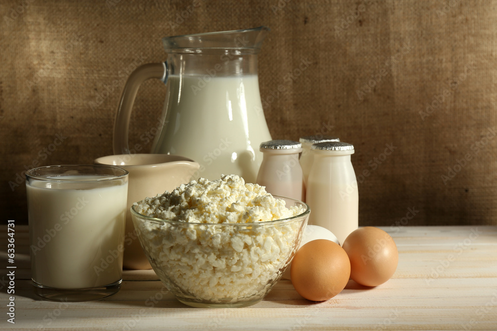 Tasty dairy products on wooden table, on sacking background Tasty dairy products on wooden table, on sacking background