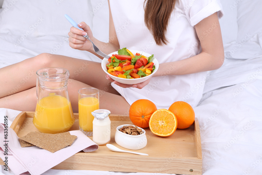 Woman in bed with light breakfast Woman in bed with light breakfast