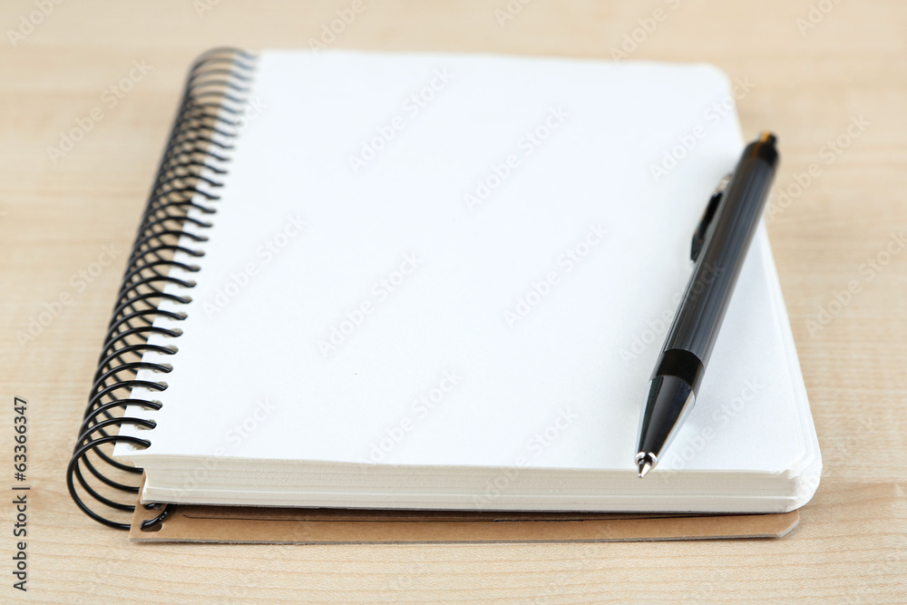 Notebook with pen on color wooden background Notebook with pen on color wooden background
