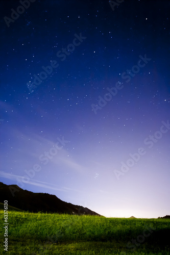 Night landscape with stars and meadow
