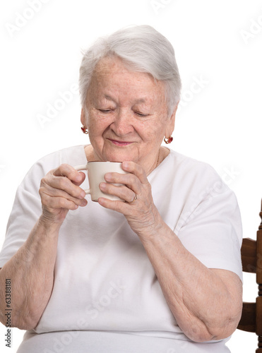 Old woman enjoying coffee or tea cup
