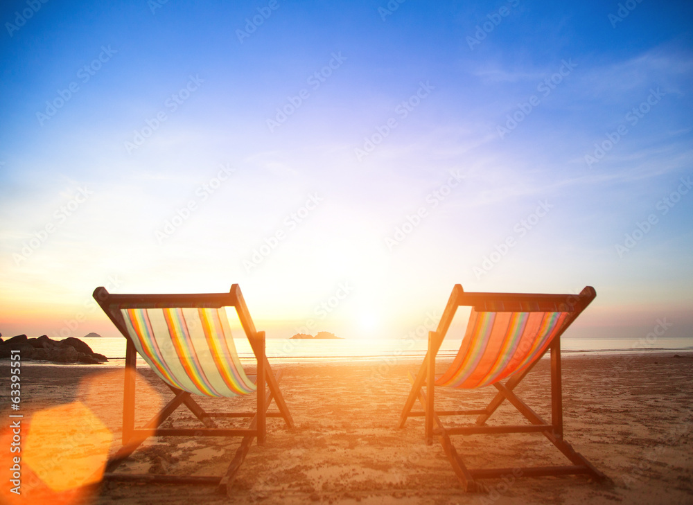 Couple of beach chairs on sea coast.