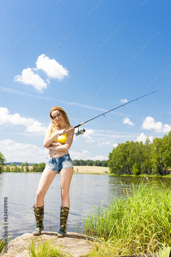 young woman fishing at pond in summer young woman fishing at pond in summer