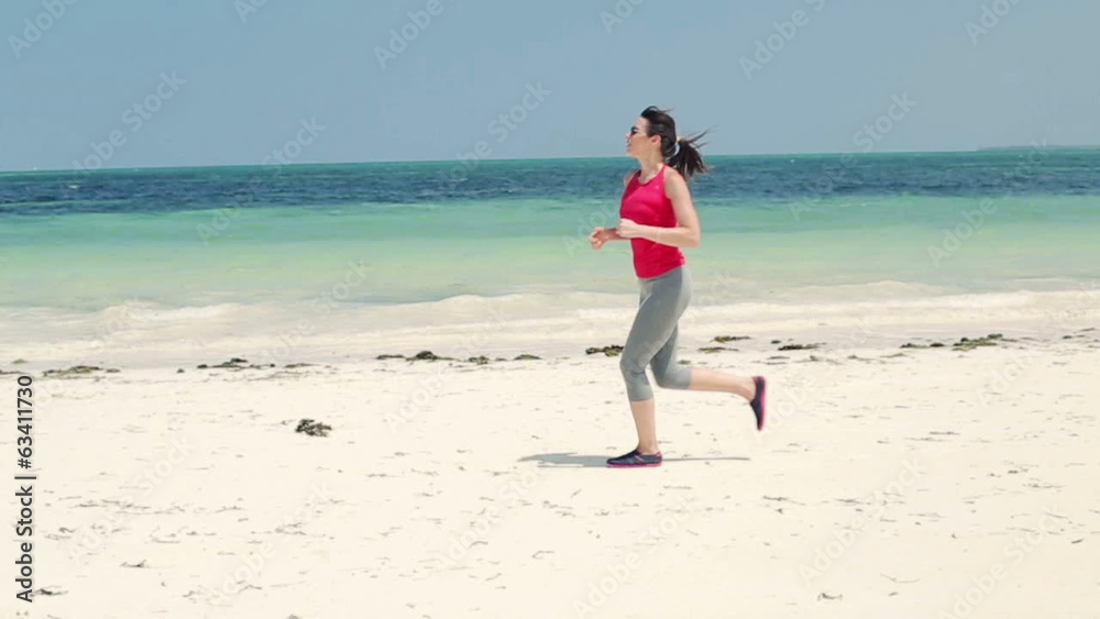 Young woman jogging on exotic beach, slow motion Young woman jogging on exotic beach, slow motion
