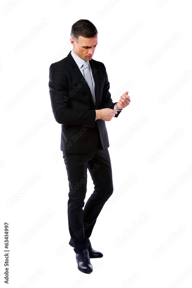Full-length portrait of a businessman buttoning cuff sleeves Full-length portrait of a businessman buttoning cuff sleeves